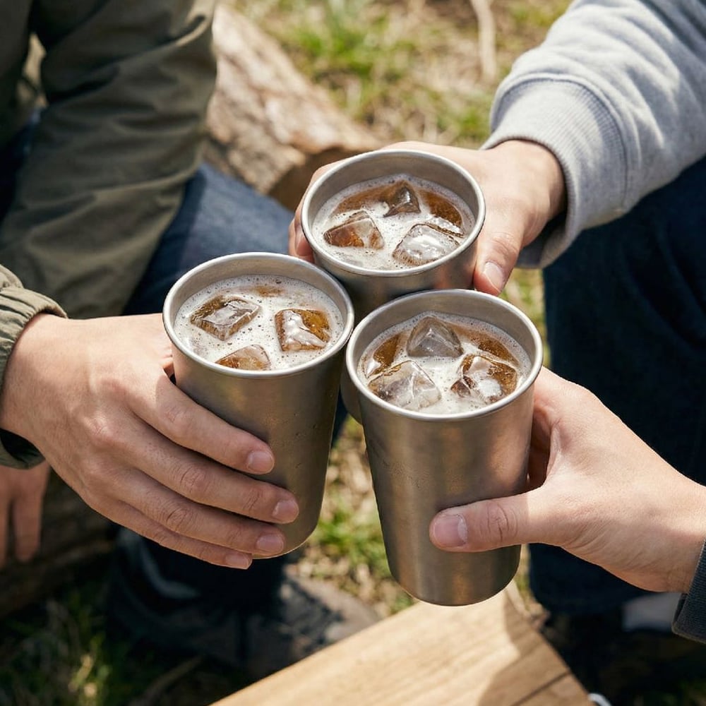 Friends toasting with three titanium beer cups outdoors