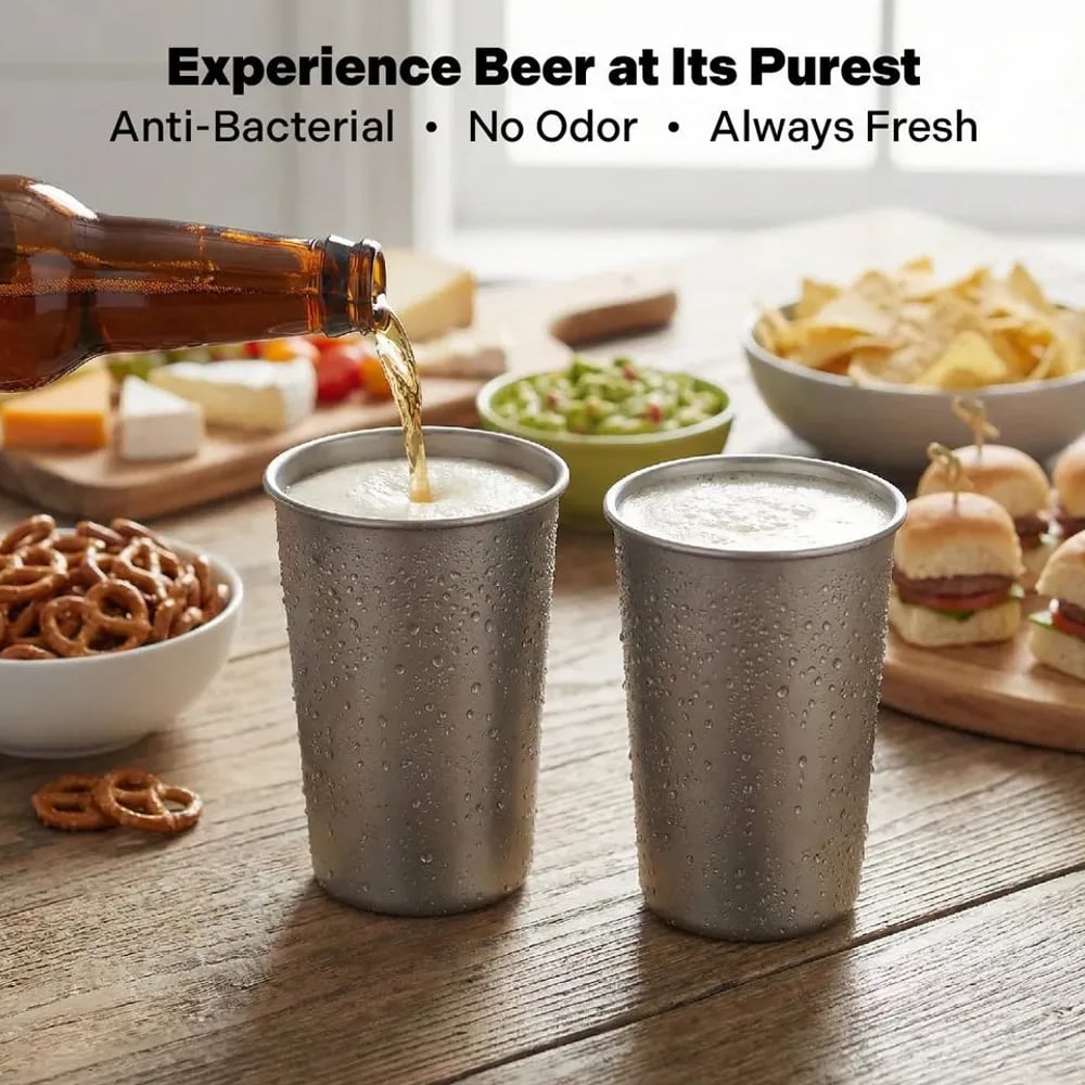 Beer poured into titanium beer cups with snacks on a table