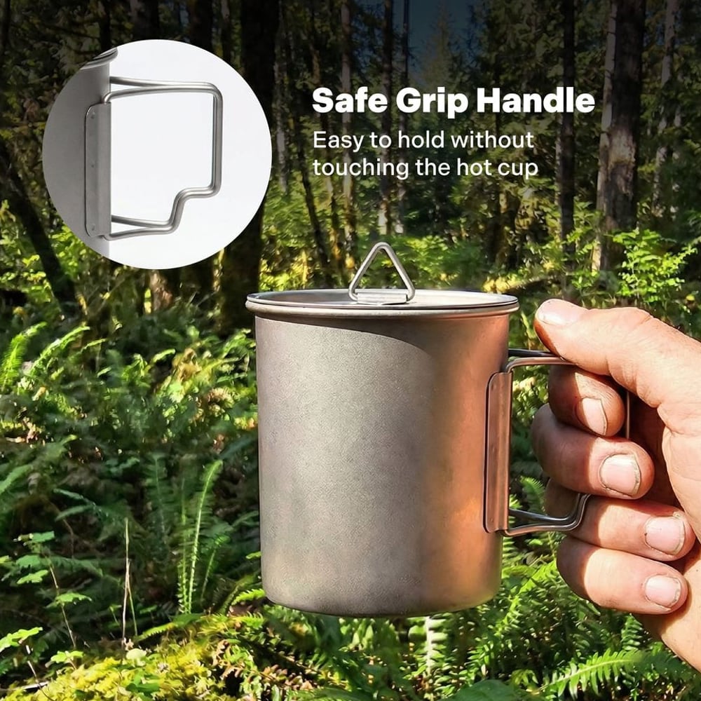 Hand holding a titanium camping cup by its handle in the forest